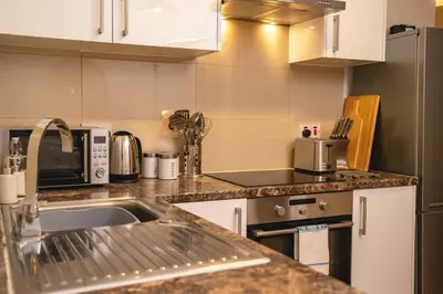 a kitchen with a sink and a microwave at Boho Style - KING BED, Central, Super FAST Wi-Fi in Cambridge