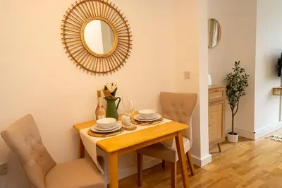 a dining room with a table and a mirror at Boho Style - KING BED, Central, Super FAST Wi-Fi in Cambridge