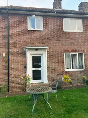 a bench in front of a brick house at Comfortable rooms upstairs at number 8 in Moulton