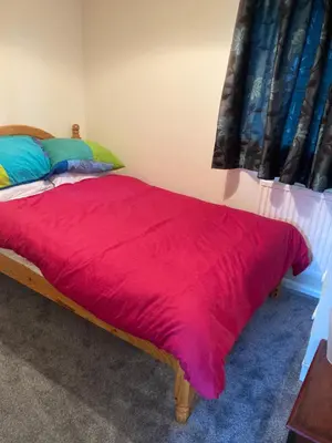 a bedroom with a bed with a red blanket at Comfortable rooms upstairs at number 8 in Moulton