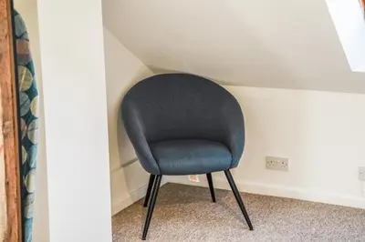 a blue chair sitting in a corner of a room at Comfortable 4-BDR House, Sleeps 7, WIFI, Secure Parking in Cambridge