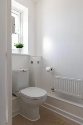 a white bathroom with a toilet and a window at Weekly & Monthly Rates! Stunning Home By Stansted Airport in Bishops Stortford