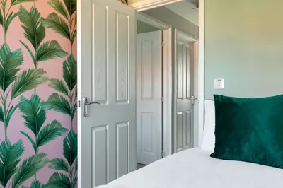 a bedroom with a bed with a green pillow at Weekly & Monthly Rates! Stunning Home By Stansted Airport in Bishops Stortford