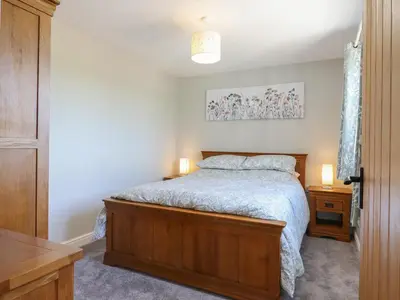 a bedroom with a bed and two night stands at Pippin Cottage in Clacton-on-Sea