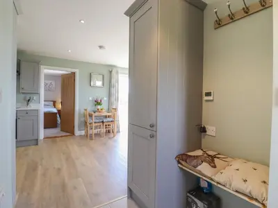 a room with a bed and a kitchen with a table at Pippin Cottage in Clacton-on-Sea
