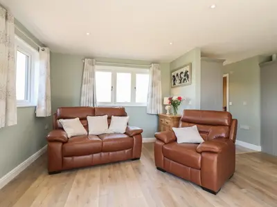 two leather chairs and a couch in a living room at Pippin Cottage in Clacton-on-Sea