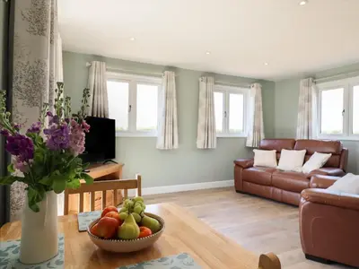 a living room with a table and a couch at Pippin Cottage in Clacton-on-Sea