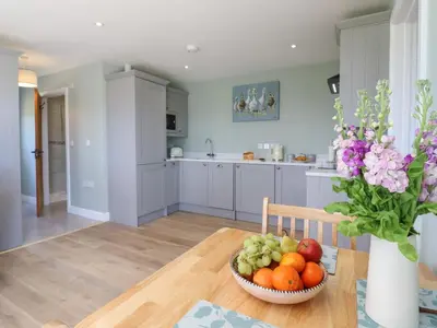 a kitchen with a bowl of fruit on a table at Pippin Cottage in Clacton-on-Sea