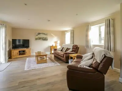a living room with a couch and a television at Bramley Cottage in Clacton-on-Sea