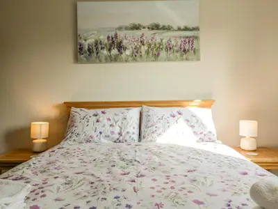 a bedroom with a bed with pink flowers on it at Bramley Cottage in Clacton-on-Sea