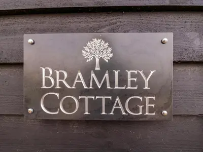 a sign on the side of a building with a tree at Bramley Cottage in Clacton-on-Sea