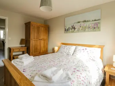 a bedroom with a bed and a painting on the wall at Bramley Cottage in Clacton-on-Sea