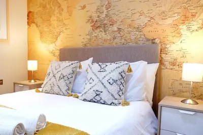 a bedroom with a bed with a map on the wall at Stunning Apartment close to Cambridge Station with FREE Parking! in Cambridge