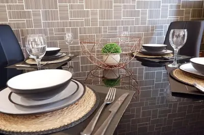 a table with plates and wine glasses on it at Stunning Apartment close to Cambridge Station with FREE Parking! in Cambridge