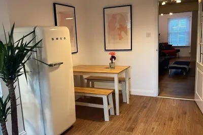 a kitchen with a table and a refrigerator at Chic 2 bedroom cottage in Willingham