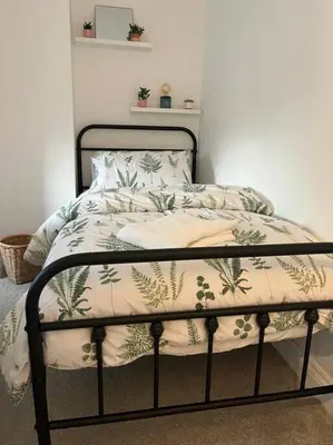 a bed with a blanket on top of it at Chic 2 bedroom cottage in Willingham