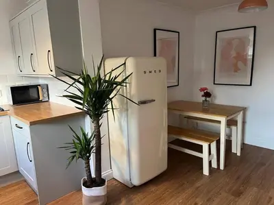a kitchen with a refrigerator next to a table and a tableablish at Chic 2 bedroom cottage in Willingham