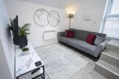 a living room with a couch and a tv at The Den - KING BED, 5 min walk to City Centre in Cambridge