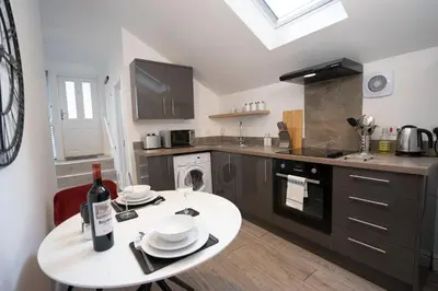 a kitchen with a table with a bottle of wine on it at The Den - KING BED, 5 min walk to City Centre in Cambridge