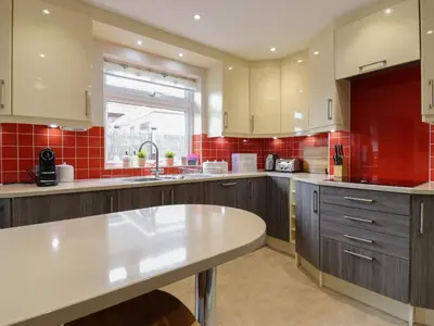 a large kitchen with a white counter top and red tiles at 256 London Road in Colchester