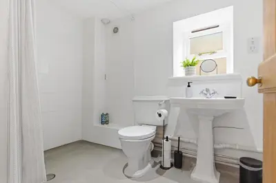 a white bathroom with a toilet and a sink at Entire 2 bed coach house in peaceful Norfolk village in Pulham