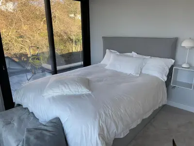 a bed with white sheets and pillows and a window at Seaside Luxury Retreat in Southend-on-Sea