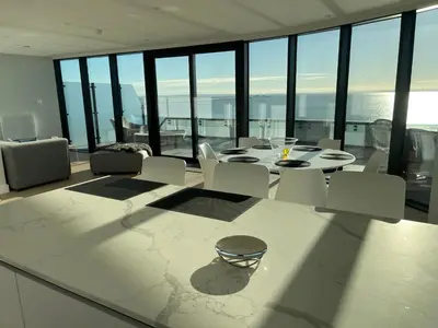 a dining room with a table and chairs and windows at Seaside Luxury Retreat in Southend-on-Sea