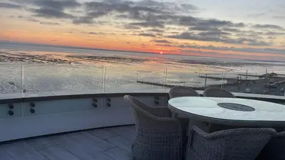 a table and chairs on a balcony with a view of the ocean at Seaside Luxury Retreat in Southend-on-Sea