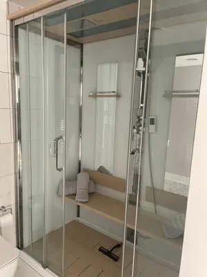 a shower stall with a bench in a bathroom at Seaside Luxury Retreat in Southend-on-Sea