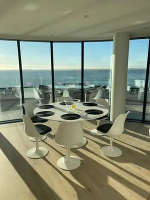 a dining room with a table and chairs and windows at Seaside Luxury Retreat in Southend-on-Sea
