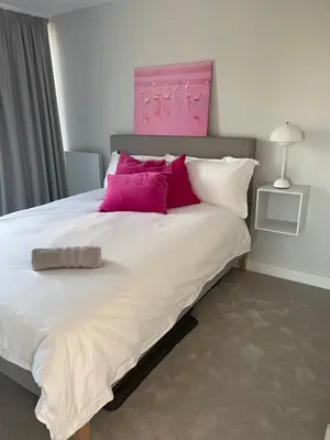 a bedroom with a large bed with pink and purple pillows at Seaside Luxury Retreat in Southend-on-Sea