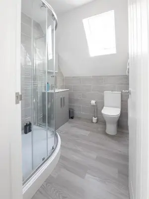 a bathroom with a glass shower and a toilet at Hedgehog Cottage in Bury Saint Edmunds