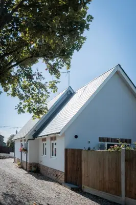 a white house with a wooden fence at Hedgehog Cottage in Bury Saint Edmunds