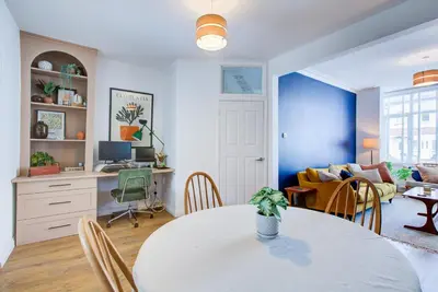 a living room with a table and a couch at Cosy house on the seafront - Pass the Keys in Southend-on-Sea