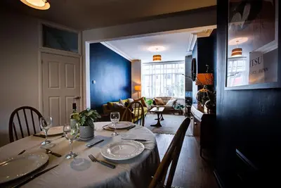 a dining room table with plates and wine glasses at Cosy house on the seafront - Pass the Keys in Southend-on-Sea