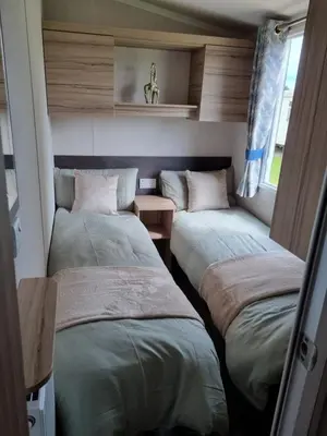 a room with two beds in a room at Modern Family Caravan with WiFi at Valley Farm, Clacton-on-Sea in Great Clacton
