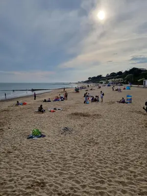 a group of people sitting on a beach at Modern Family Caravan with WiFi at Valley Farm, Clacton-on-Sea in Great Clacton