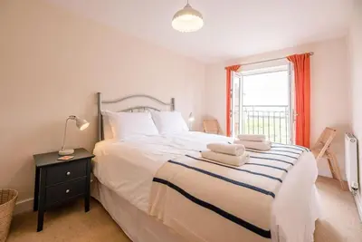 a bedroom with a bed with two towels on it at Spindrift, Felixstowe in Felixstowe