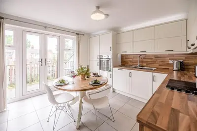 a kitchen with a table and chairs in a kitchen at Spindrift, Felixstowe in Felixstowe