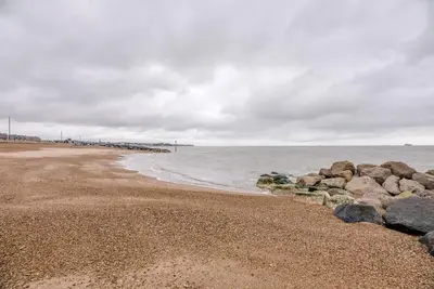 a group of rocks on a beach near the water at Spindrift, Felixstowe in Felixstowe