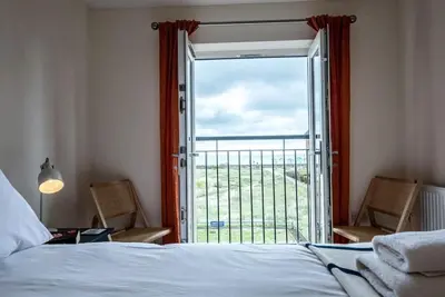 a bedroom with a bed and a sliding glass door at Spindrift, Felixstowe in Felixstowe