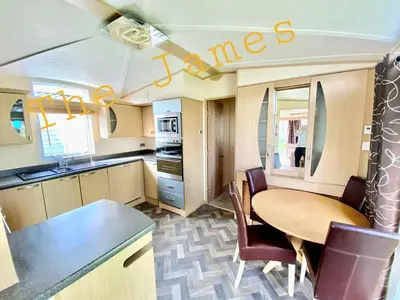 a kitchen with a table and chairs in a caravan at The James Lodge in Little Clacton