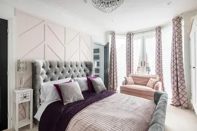 a bedroom with a large bed with a purple blanket at Beautiful Spacious Beach Home Newly Renovated in Felixstowe
