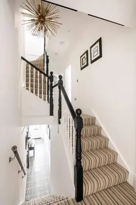 a staircase in a home with white walls and a stair case at Beautiful Spacious Beach Home Newly Renovated in Felixstowe