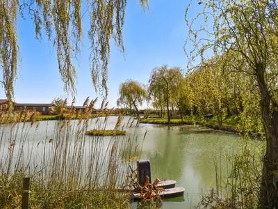 a pond with a bench in front of it at Lodge 38 in Stowmarket