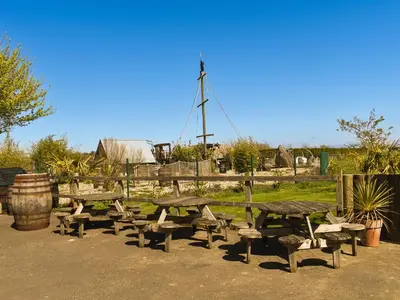 a group of picnic tables and benches in a field at Lodge 38 in Stowmarket