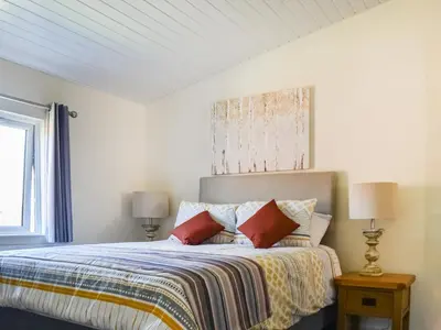 a white bedroom with a bed with pillows at Lodge 38 in Stowmarket