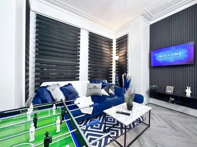 a living room with a couch and a tv at Swanky Seaside Sanctuary w foozeball - Southend in Southend-on-Sea