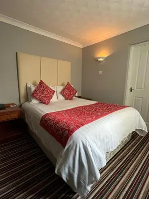 a bedroom with a large bed with red pillows at Sorrento Hotel & Restaurant in Cambridge