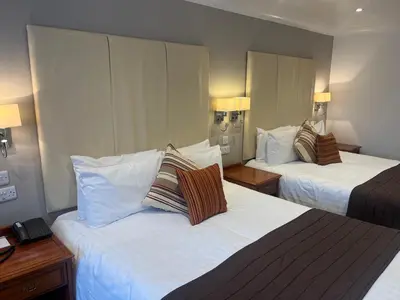 a hotel room with two beds with white sheets at Sorrento Hotel & Restaurant in Cambridge